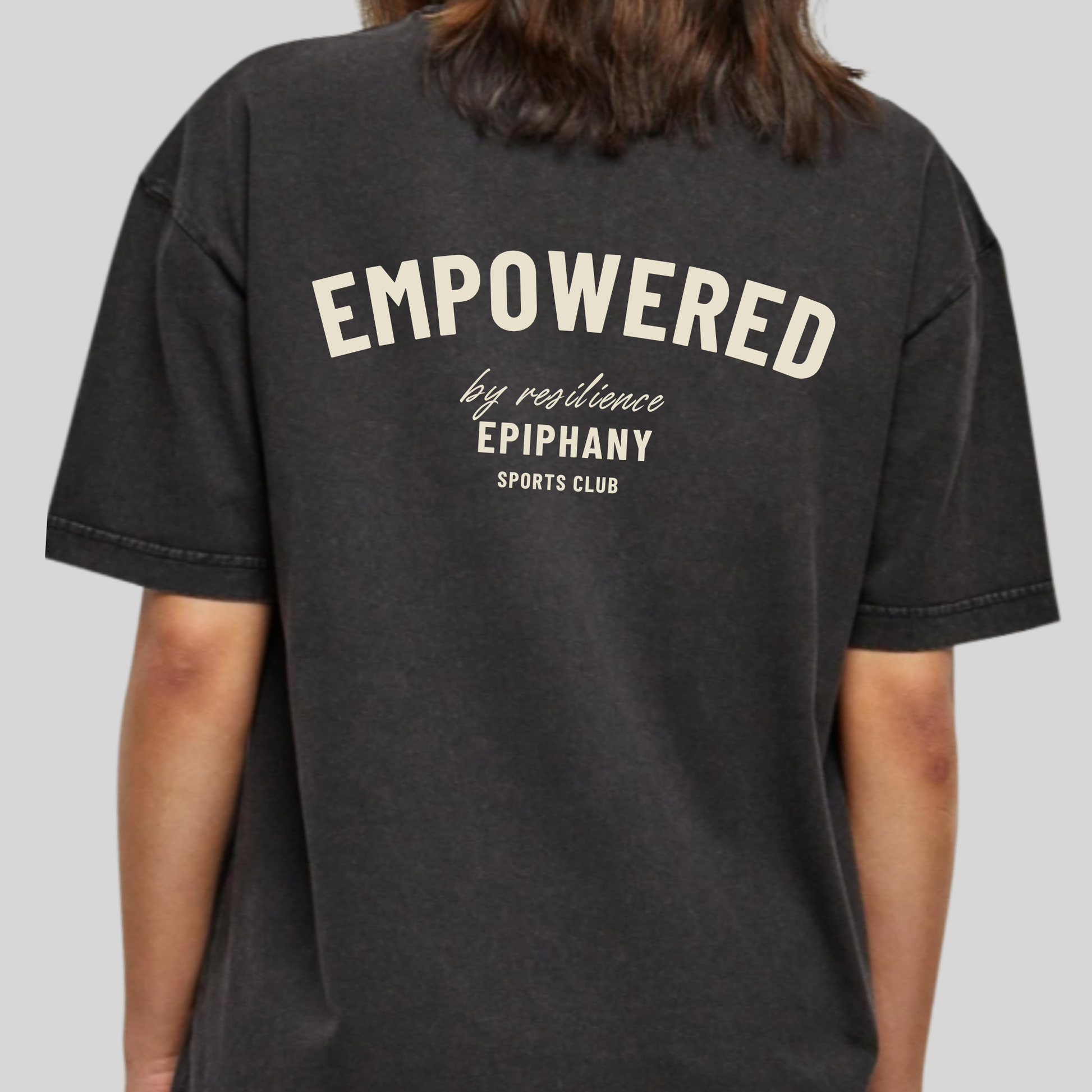 Women's back oversized acid wash T-shirt featuring 'Empowered by Resilience' design.